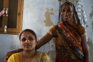 Widow Santosh Komodi (right) poses next to Savita Sharma (left), one of six human rights defenders trained by UN Women, in Vrindavan, northwestern India. Santosh is one of 62 widows who recently received the widow’s pension. Photo credit: Caroline Pankert