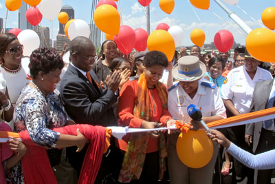 UN Women Executive Director Phumzile Mlambo-Ngcuka cuts the ribbon at Nelson Mandela Bridge, which will be lit up in orange until the end of 16 days of activism, on 10 December to mark UN Women’s&nbsp;“Orange the world” efforts under the UNiTE campaign. Photo: UN Women/Helen Sullivan