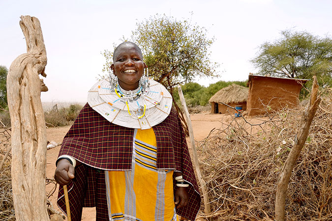 Mama Neema a la entrada de su boma tradicional (finca), donde construyó tres casas para su familia en la aldea de Kimokouwa en Arusha, Tanzanía. Foto: ONU Mujeres/Deepika Nath.