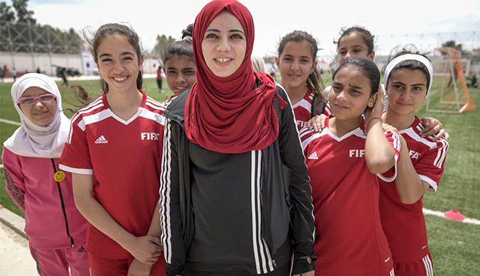 Syrian refugee and Jordanian girls participate in a mixed-nationality football camp in Jordan. Photo: UN Women/Christopher Herwig