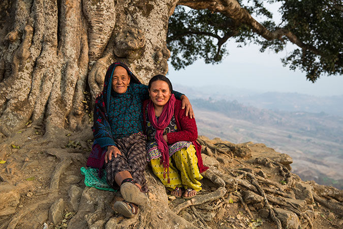 Maali Gurung, left, puts her arm around Suk Maya Gurung, a fellow displaced earthquake survivor who works as social mobilizer at the Multi-purpose Women’s Centre. Photo: UN Women/Narendra Shrestha