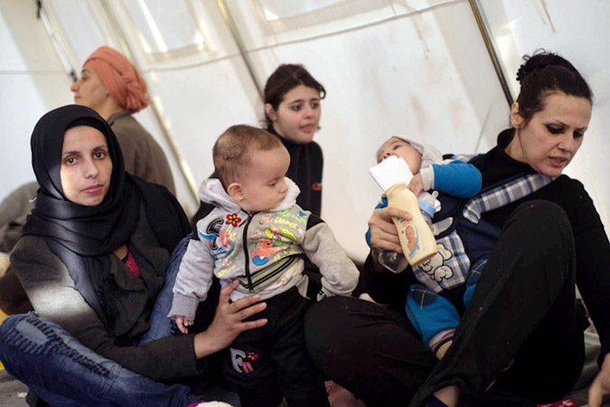 Women carrying babies in the one stop center in Presevo, Serbia. Photo credit: Mirjana Nedeva