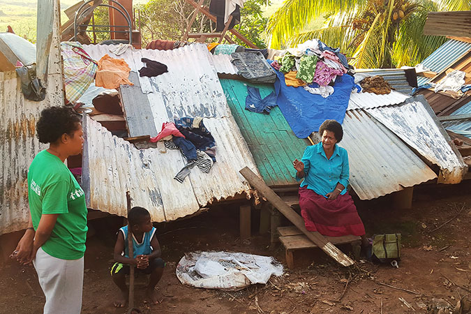 Unaisi Racaca talks to UN Women staff by what remains of her home just outside Lautoka. Photo: UN Women/Kasanita Isimeli