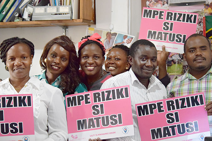 Market traders and visitors promote ending violence against women. Photo: UN Trust Fund/Gemma Wood