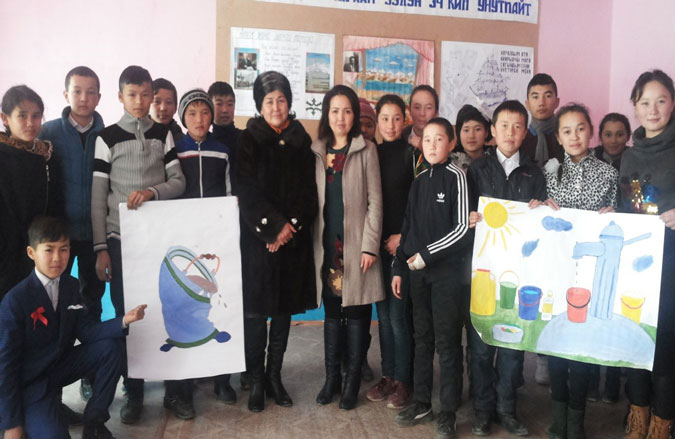 Erlan and his teammates with Ms. Roza Shamaeva, the head of the rural council. Photo: Un Women/Dildora Khamidova