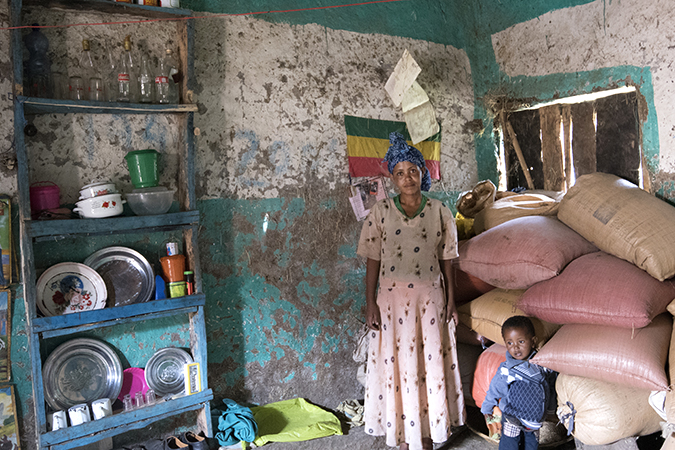 Birtukan Fekadu inside her home with sacks of grains she helped produce. Photo: UN Women