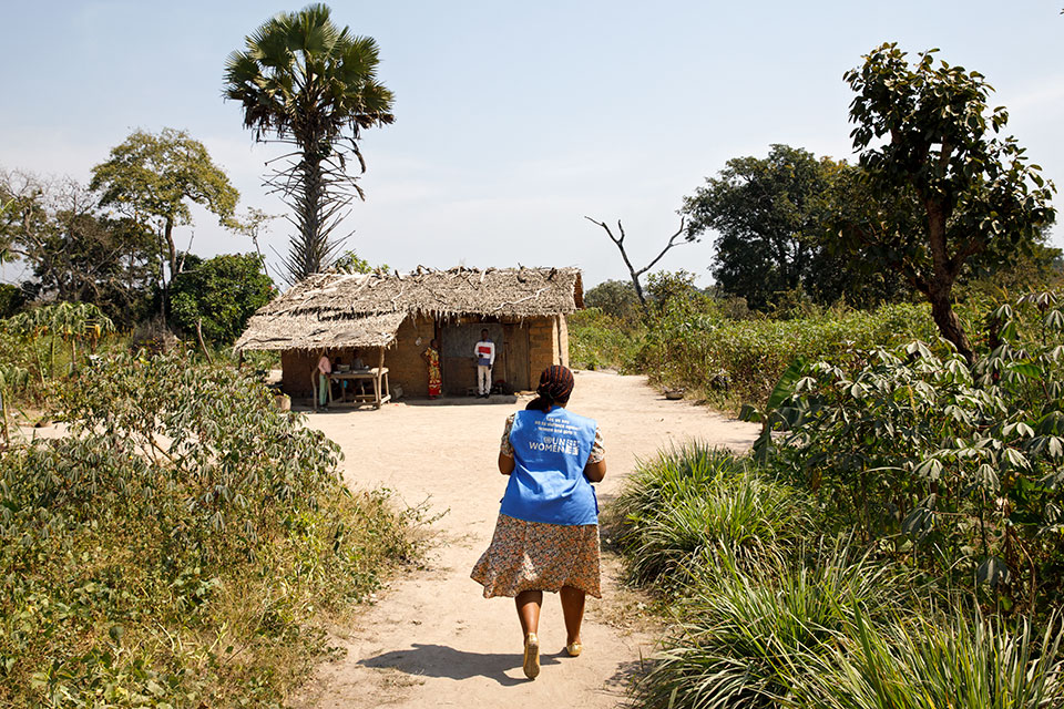 Odette Bienel, a community worker with UN Women working on the Gender Road Project, visits a family which she helped obtain birth certificates, allowing their girls to go to school. Photo: UN Women/Ryan Brown