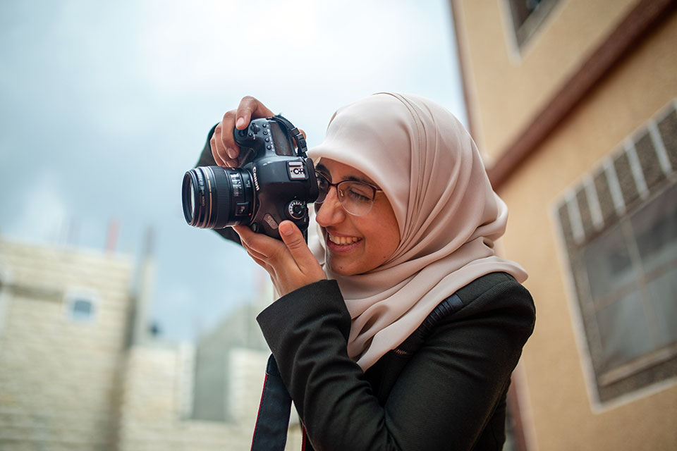 Doaa Eshtayeh taking a photo. Photo: UN Women/Carlos Pérez Osorio