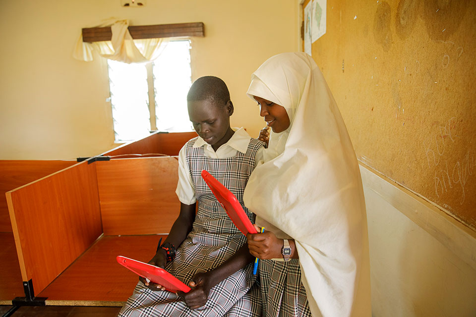 Nyamam Gai Gatluak and her classmate, Umuhoza Hurlarain, explore the internet and talk about their latest coding project. Both girls are students of Angelina Jolie Primary School in Kakuma refugee camp. Photo: UN Women/Ryan Brown