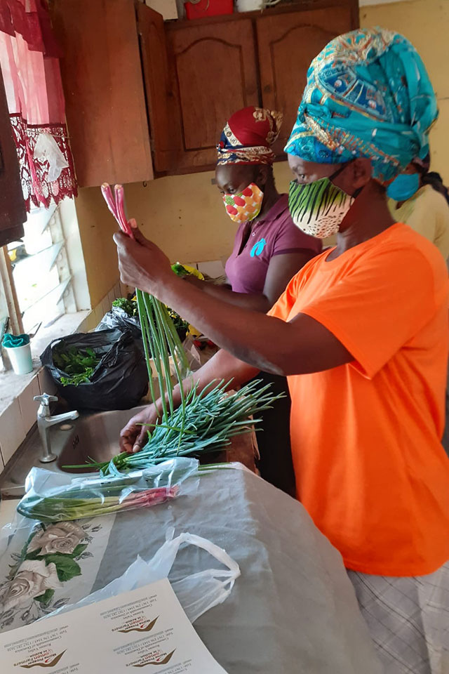 Women farmers package and label vegetables for sale at a member’s home, as their factory construction was stalled due to COVID-19 restrictions on movement and work. Photo: UN Women/Dawn Francis