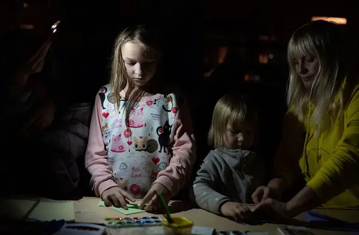 Children play amid electricity cuts, air raids, and attacks on the city of Kharkiv, Ukraine, on 15 November 2022.