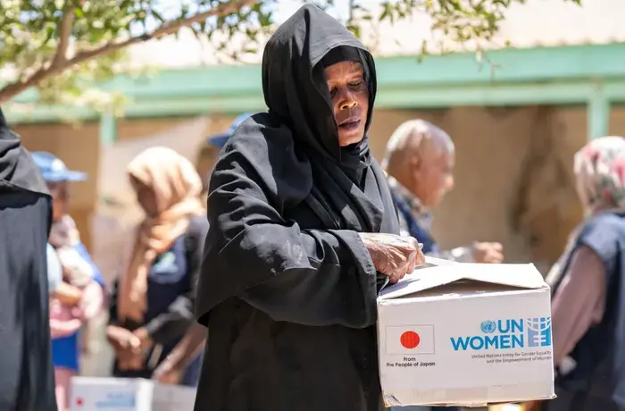 A woman opens a box labelled "UN Women"