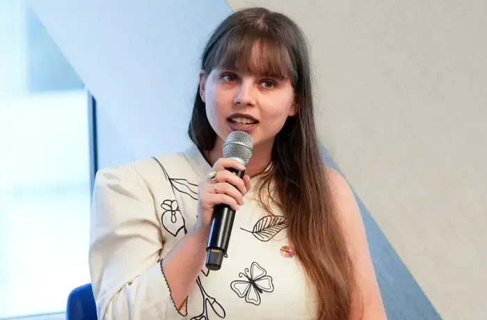 A young woman speaks into a microphone