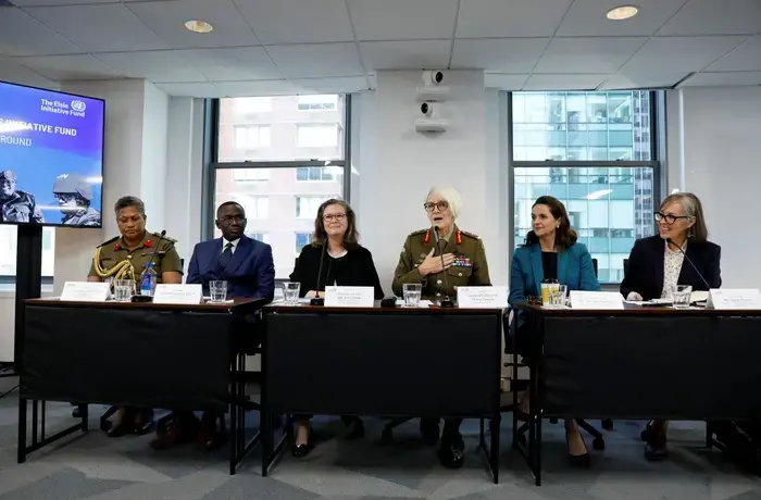 Six people, including some in military uniforms, speak on a panel
