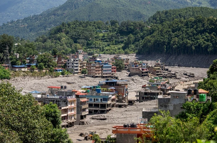 A village is devastated by floods, thick with mud and debris