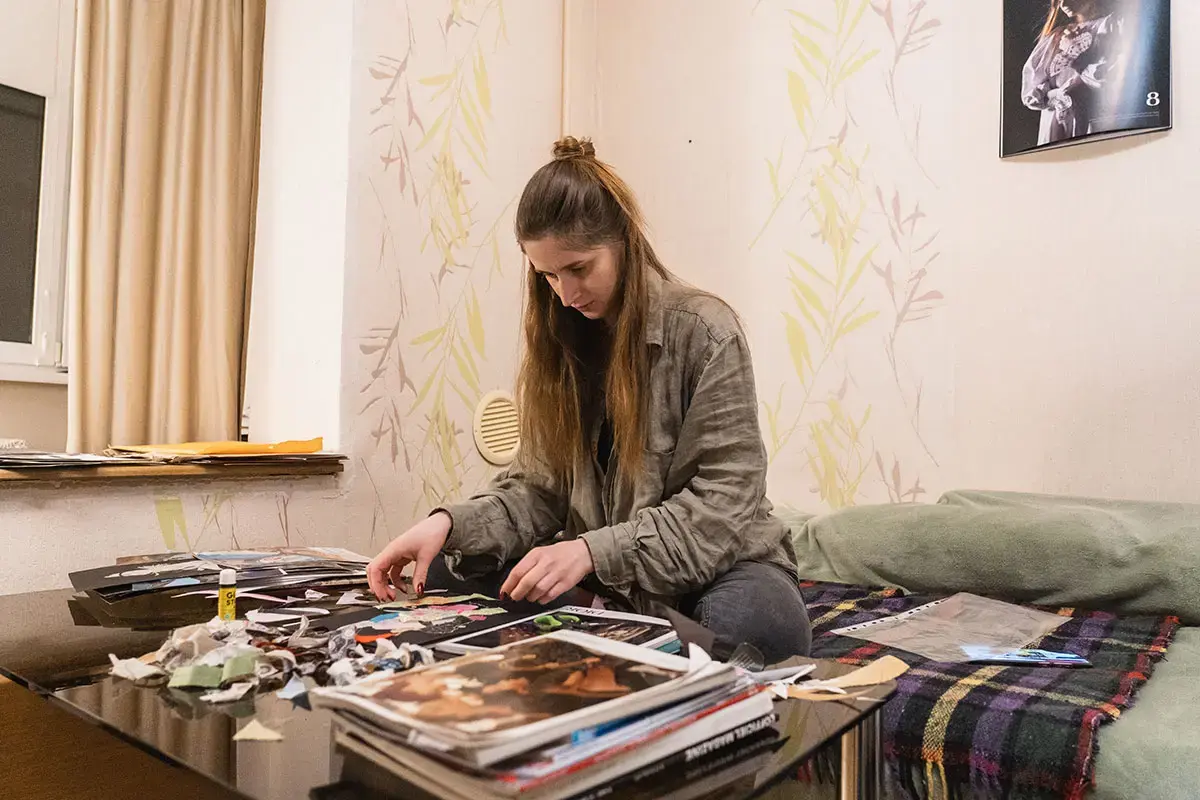 Daria Zymenko, in her room in Kyiv, creating a collage.