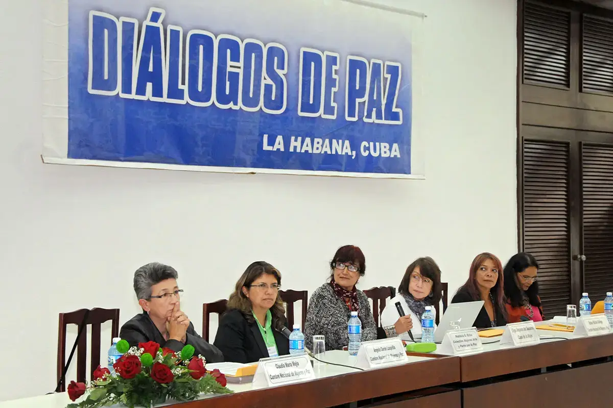 Panel de ponentes bajo la pancarta de Diálogos de Paz