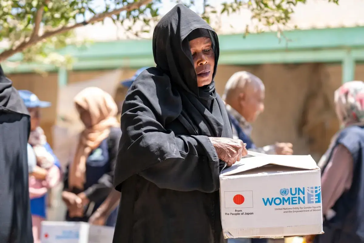 A woman opens a box labelled "UN Women"
