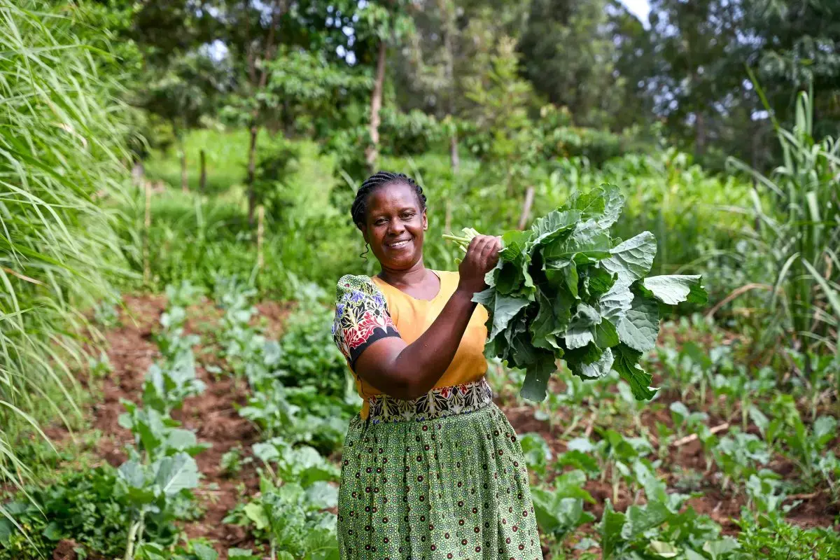 A woman holds up fresh greens