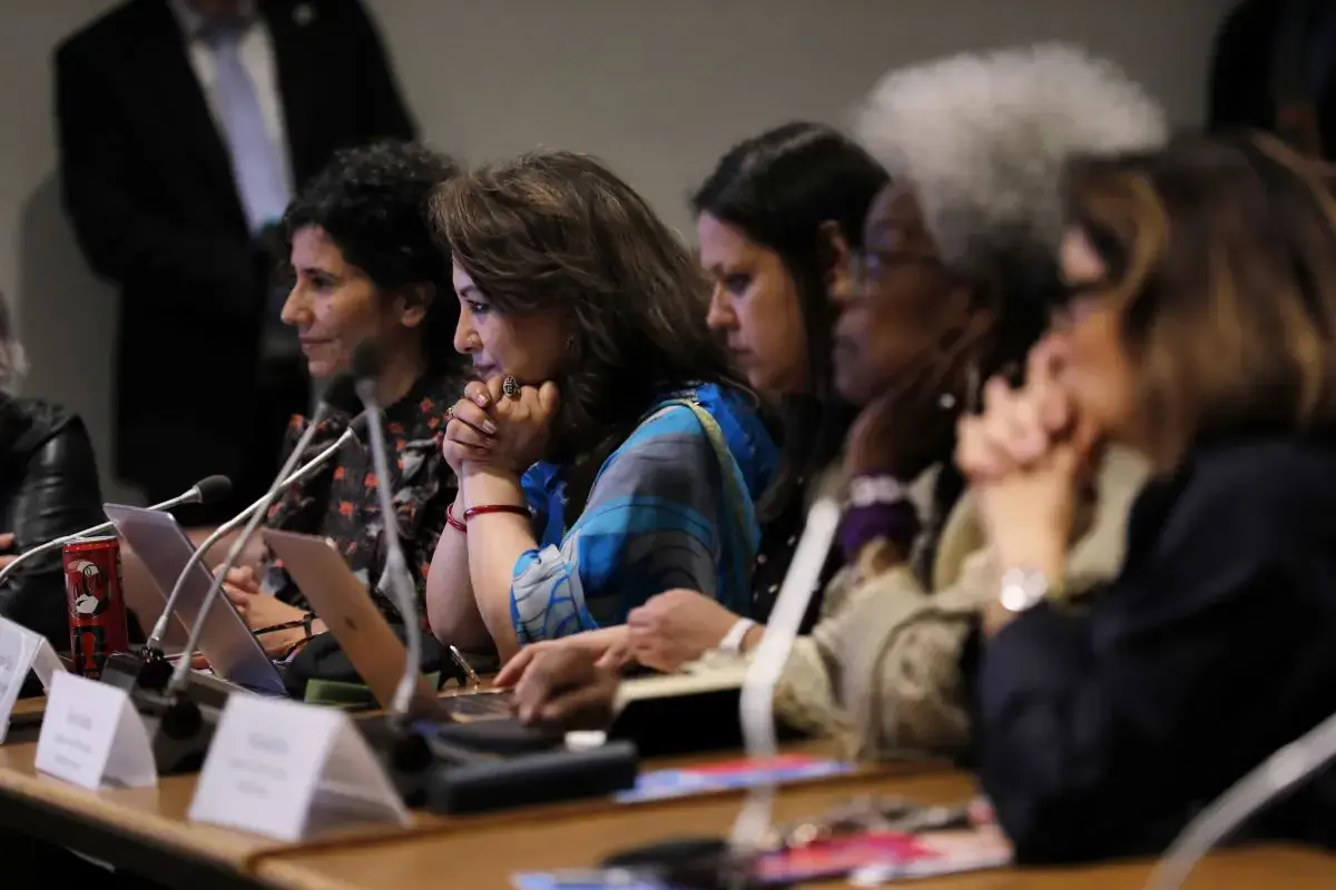 Women listen to a speaker's remarks
