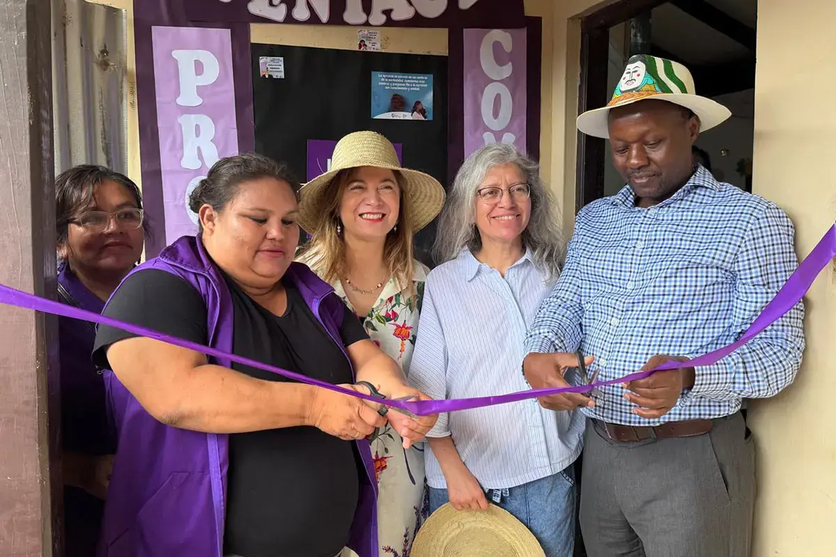 A group of people cut a purple ribbon during an opening ceremony.