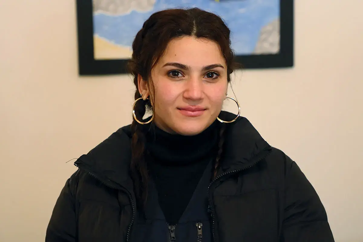 A portrait of a woman looking at the camera indoors.