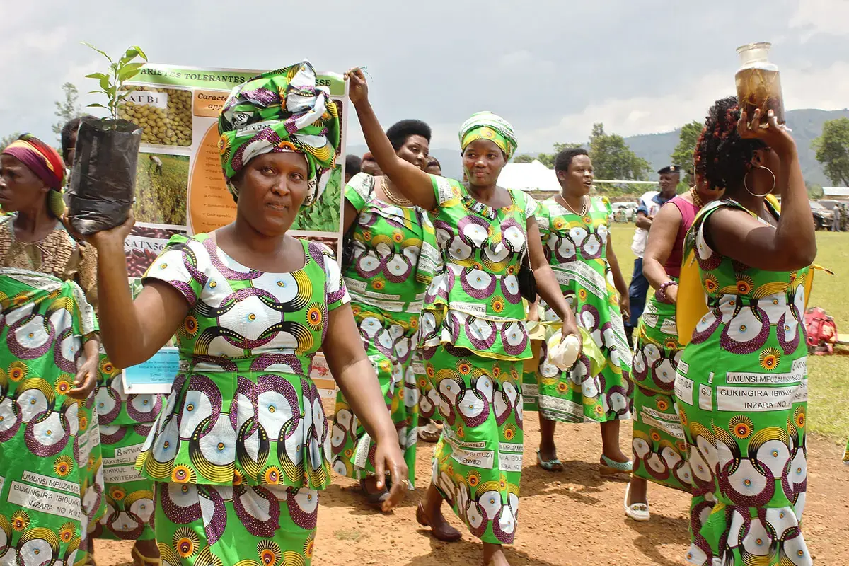 Un groupe de femmes vêtues de tenues assorties aux motifs identiques défilent ensemble en plein air.