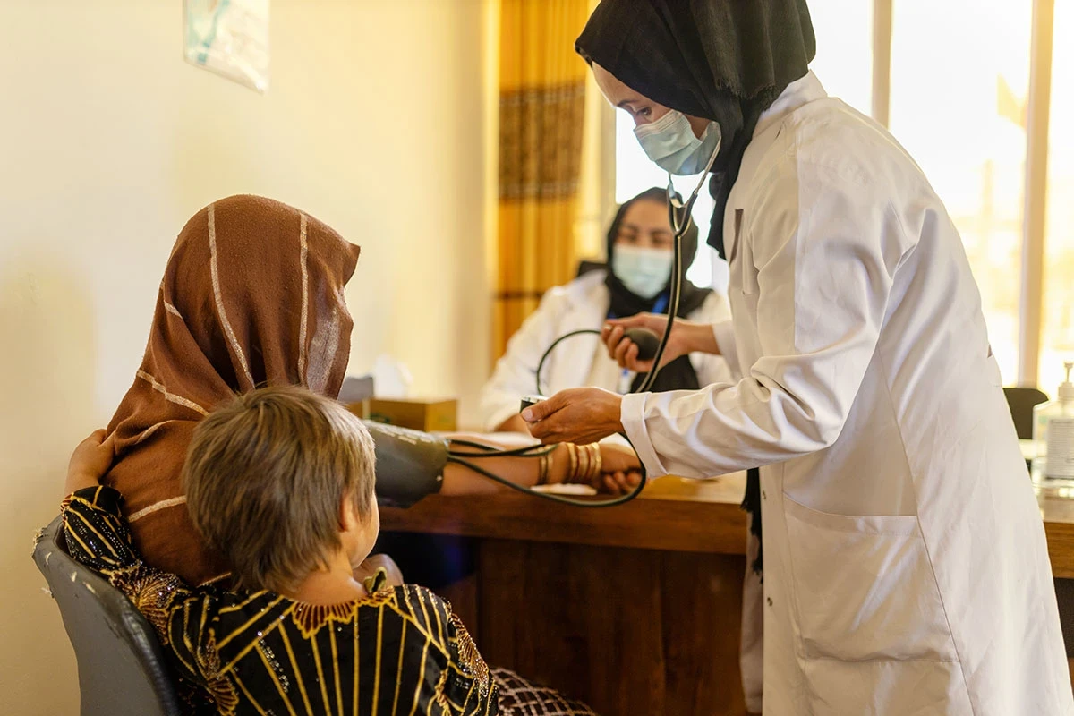 Une femme consulte une femme médecin et une pharmacienne au sein d’une organisation dirigée par des femmes, dans la région centrale de l’Afghanistan. 
